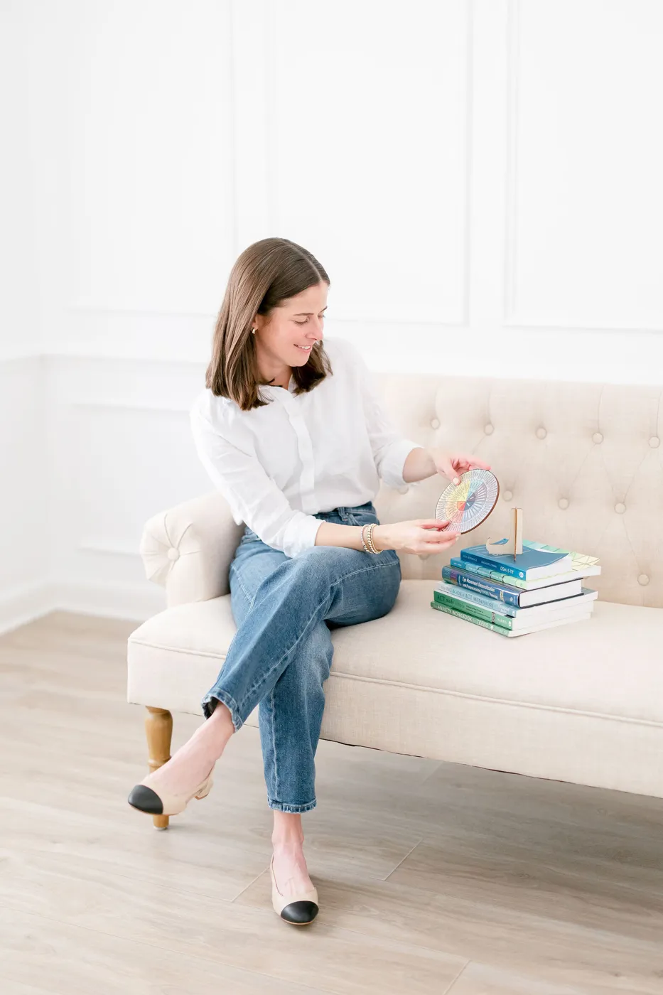 Anne-Hampton seated on a sofa holding a feelings wheel