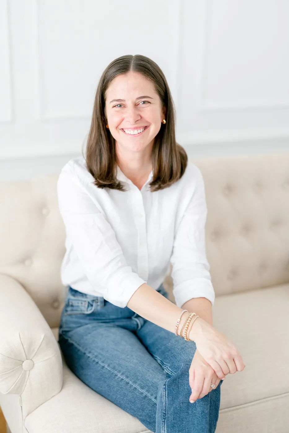 Anne-Hampton Harden smiling, seated on a sofa
